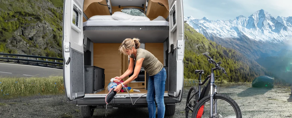 frau beim camping in einem caravan