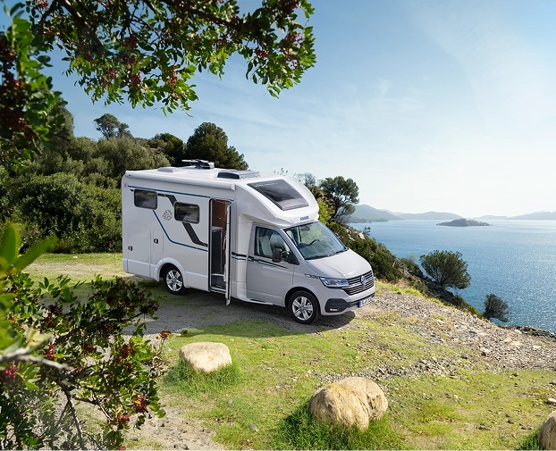 wohnmobil auf wiese im hintergurnd ein see