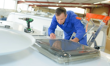 wohnmobil werkstatt mann arbeitet an luke